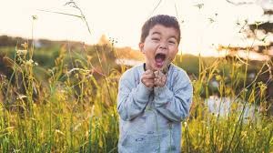 Joyful child in a field of flowers